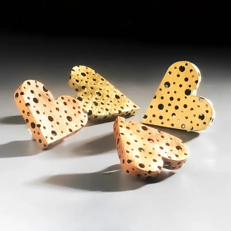 Heart Earrings in copper and brass with pierced surface and brushed texture